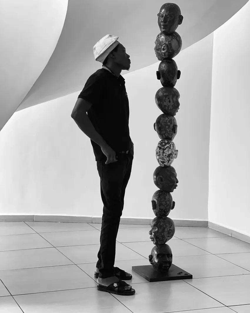 Man observing a tall sculpture
