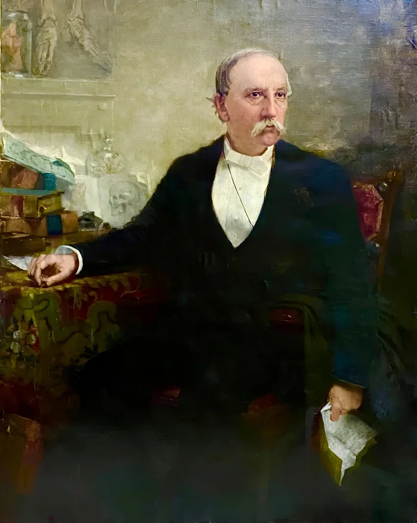 Gentleman holding paper, seated at table