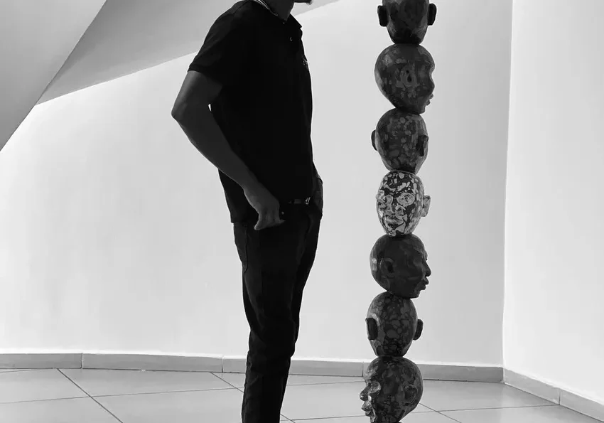 Man observing a tall sculpture