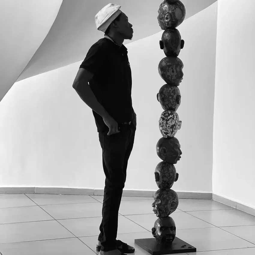 Man observing a tall sculpture