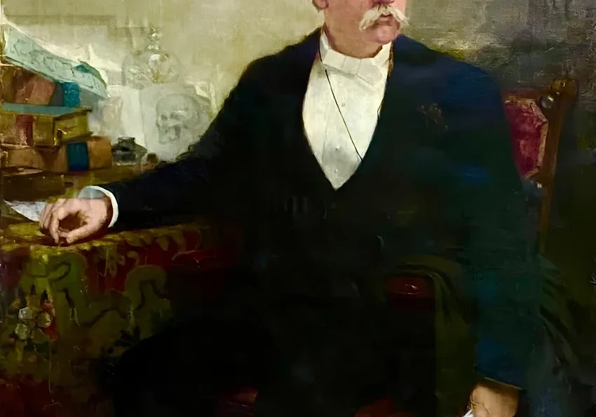 Gentleman holding paper, seated at table