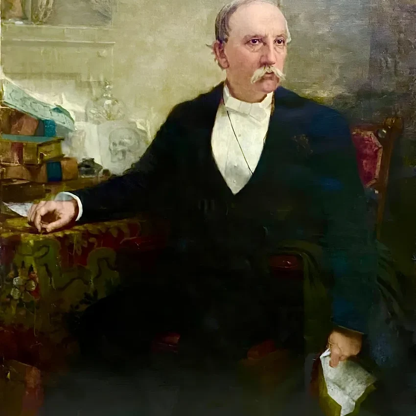 Gentleman holding paper, seated at table
