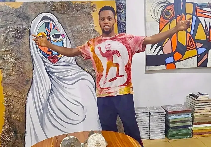Artist posing with colorful abstract paintings
